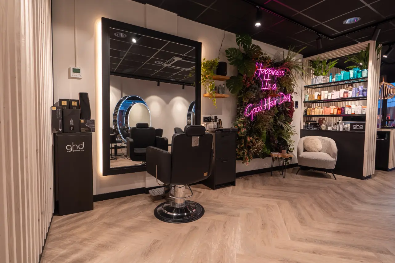 A hair salon, named Dilara's Hair, offering exquisite haarbehandelingen and top-notch haarverzorging. The salon is beautifully adorned with a mirror and plants, creating a
