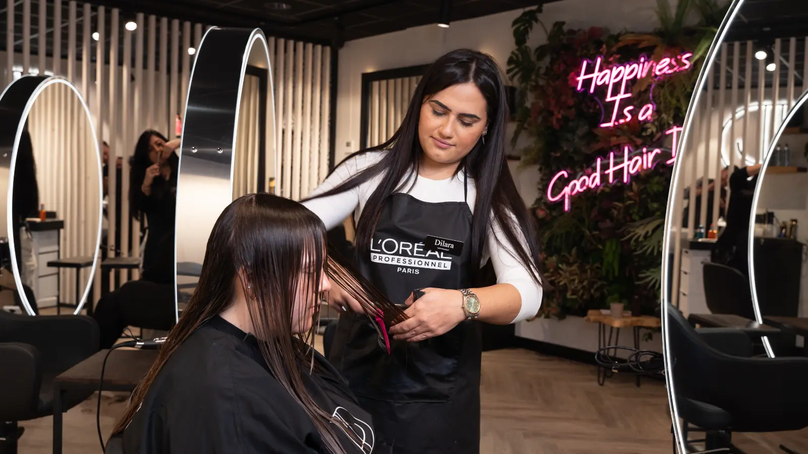 Een vrouw die een balayagebehandeling krijgt van een kleurspecialist in een salon.