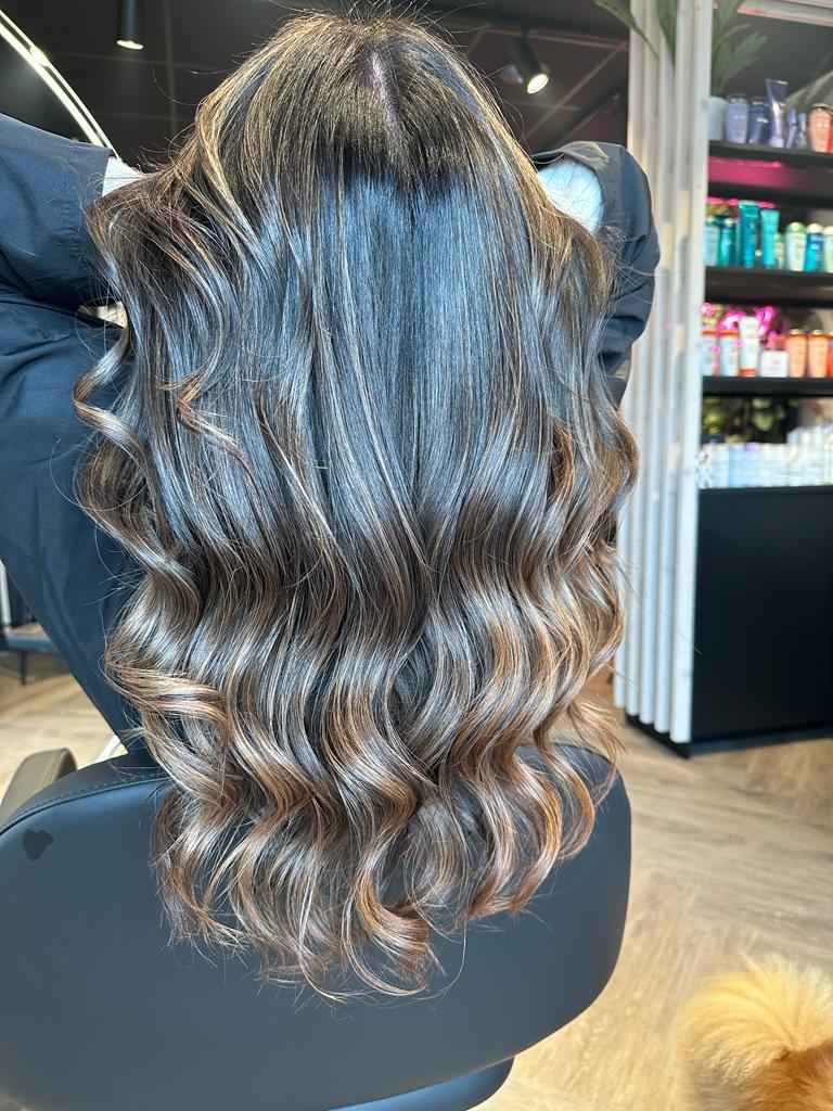 Het haar van een vrouw wordt gestyled met een proteïnebehandeling.